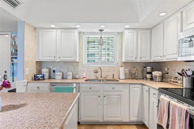 a kitchen with granite countertop cabinets sink and window