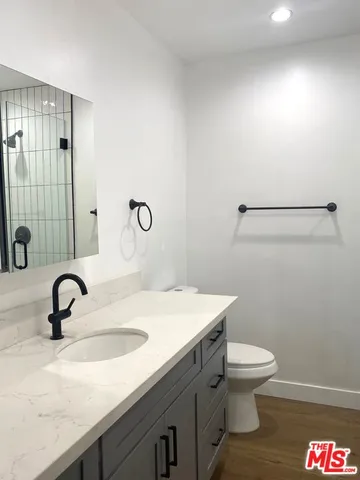 a bathroom with a sink a toilet and mirror