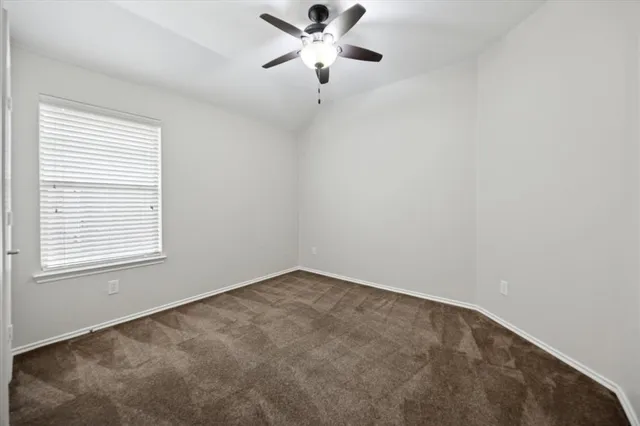 an empty room with a window and a ceiling fan