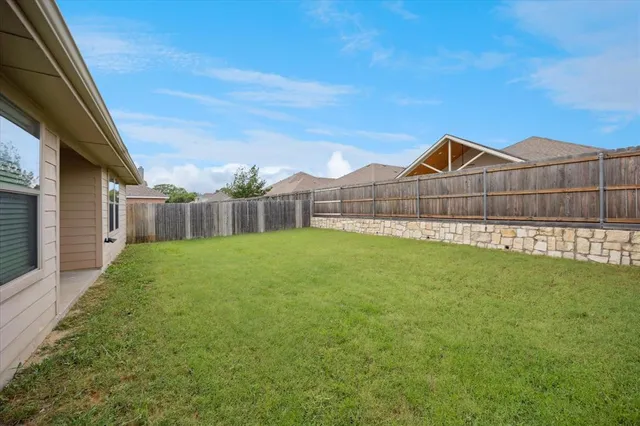 a view of a backyard with a garden and entertaining space