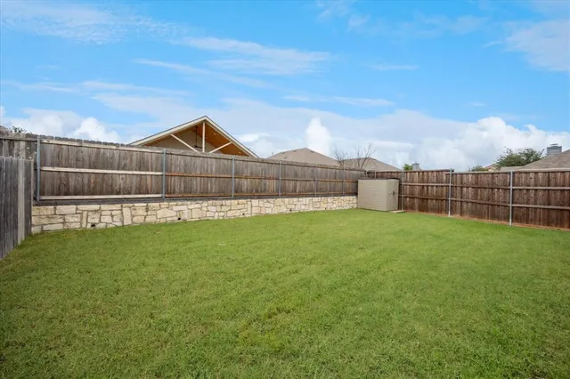 a view of a green field with a small yard