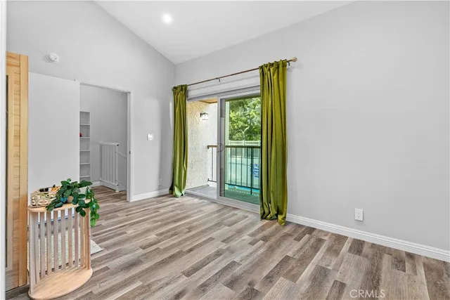 a view of a room with a large window and wooden floor