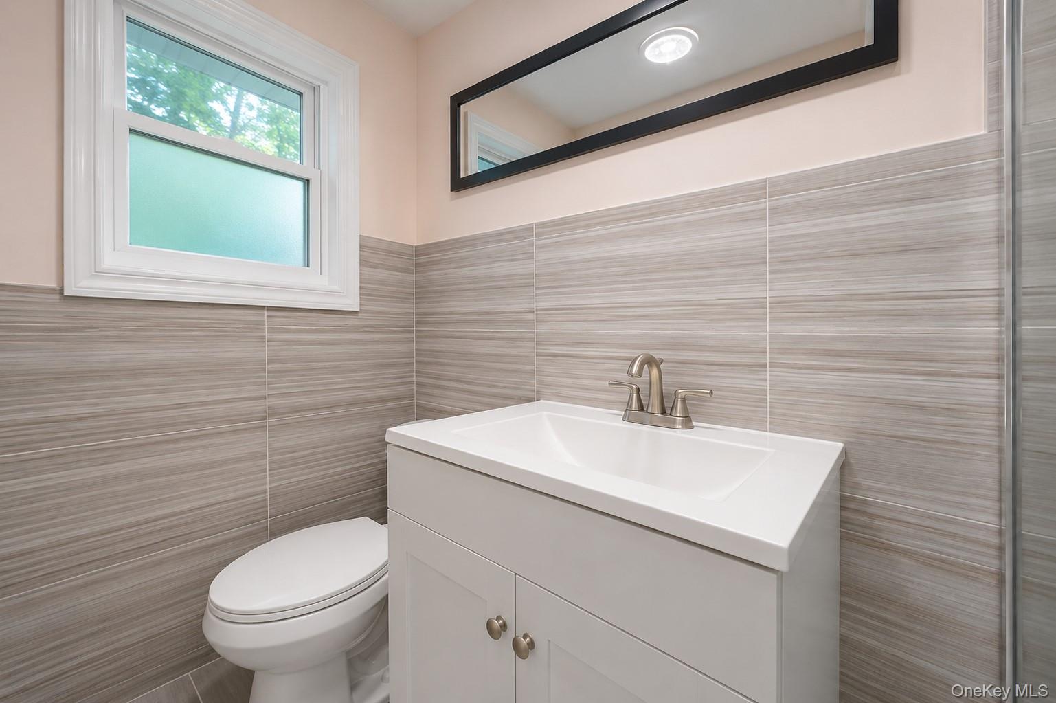1 Windsor Road Monroe, NY 10950 - Photo 14 of 20 a bathroom with a toilet a sink a mirror and a window