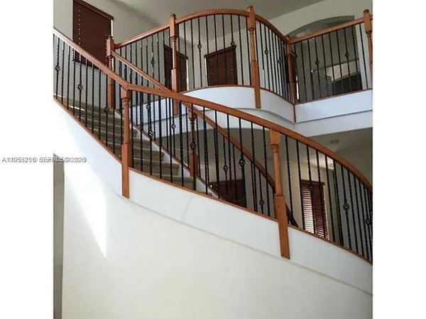 a view of staircase with railing and a chandelier