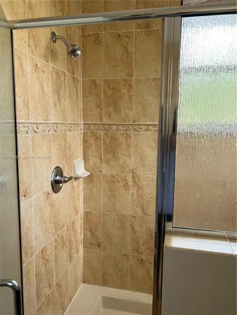 a bathroom with a granite countertop sink a mirror and a shower