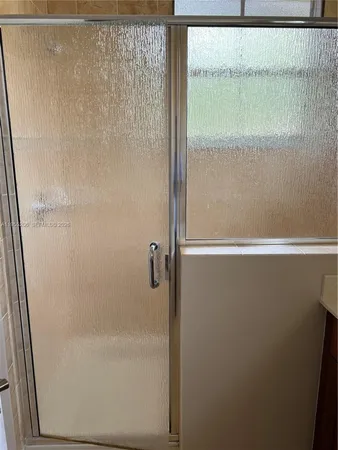 a white toilet sitting next to a shower