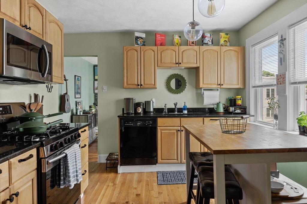 63-65 Brookley Road, Unit 3 Boston, MA 02130 - Photo 13 of 31 a kitchen with stainless steel appliances granite countertop a stove top oven a sink dishwasher and cabinets with wooden floor