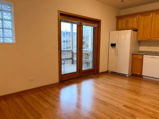 a view of a kitchen with wooden floor and a refrigerator
