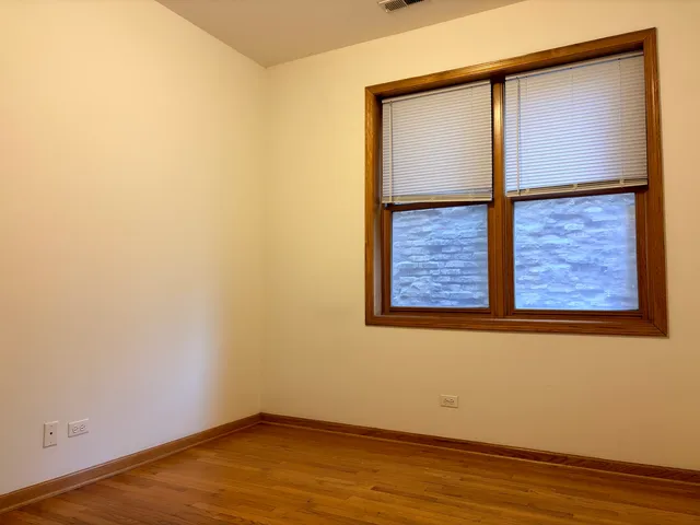 an empty room with wooden floor and a window