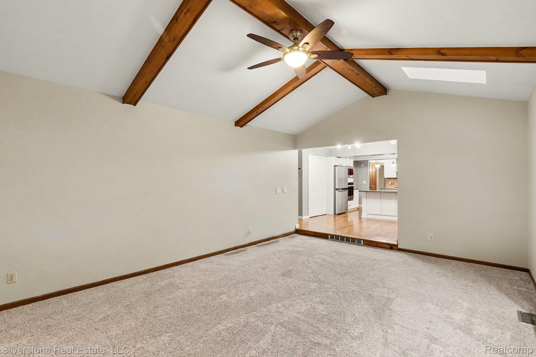 869 Timberline Drive Rochester, MI 48309 - Photo 4 of 29 Vaulted ceiling with exposed wood beams, ceiling fan, and skylight