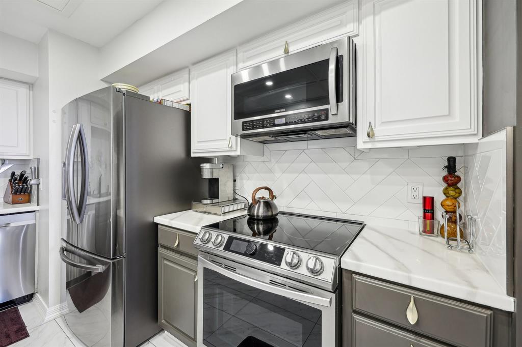 5200 Keller Springs Road, Unit 815 Dallas, TX 75248 - Photo 8 of 35 a kitchen with stainless steel appliances a refrigerator a stove and a microwave