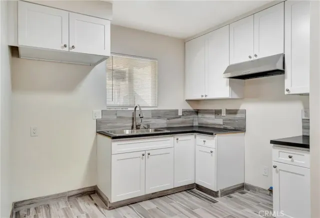 a kitchen with granite countertop white cabinets and white appliances