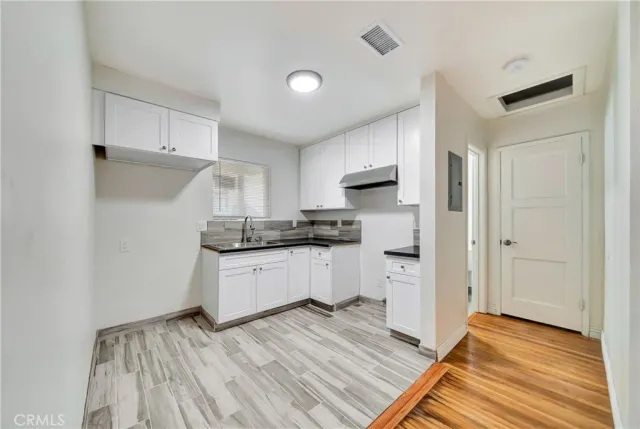 a kitchen with a refrigerator and white cabinets