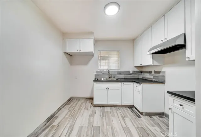 a kitchen with granite countertop white cabinets and white appliances