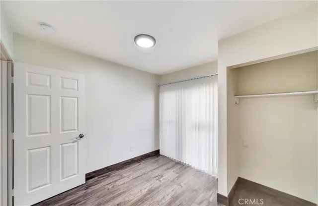 an empty room with wooden floor and closet