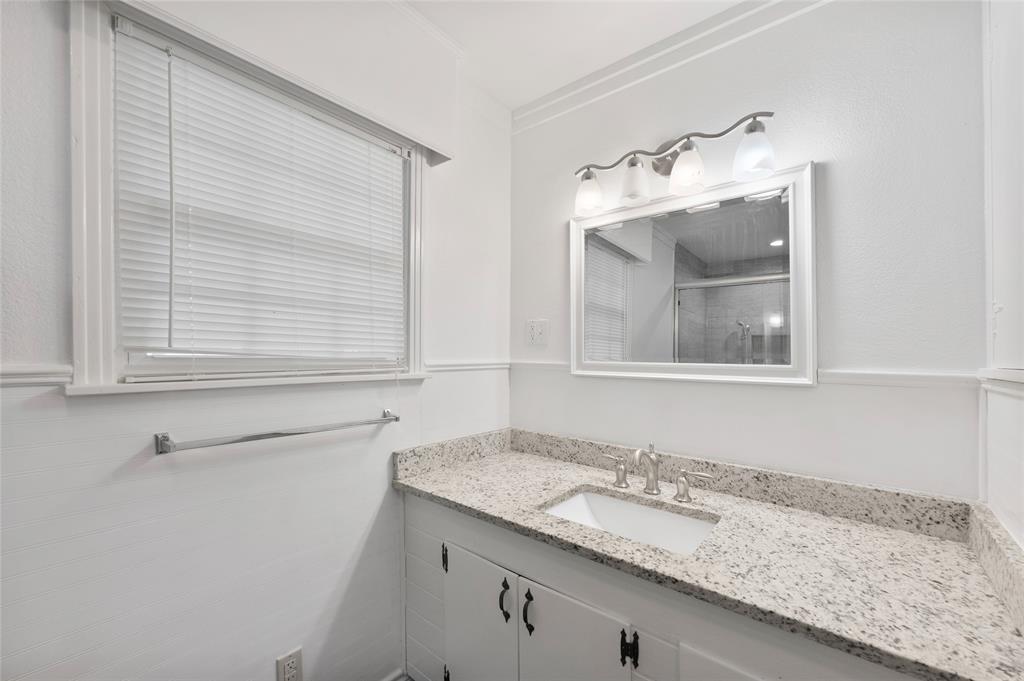 903 Lynn Street Bonham, TX 75418 - Photo 14 of 29 a bathroom with a granite countertop sink and a mirror