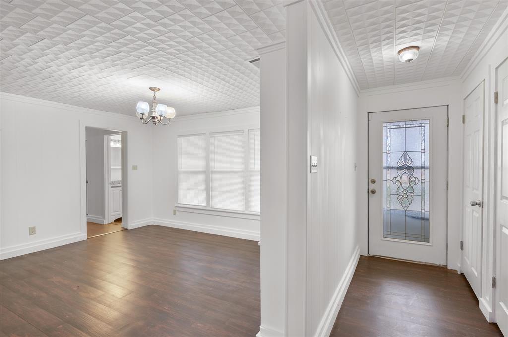 903 Lynn Street Bonham, TX 75418 - Photo 4 of 29 an empty room with wooden floor and mirror