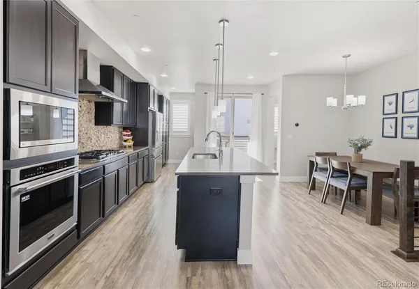 a large kitchen with stainless steel appliances kitchen island granite countertop a large island in the center