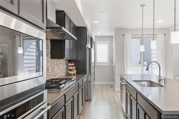 a kitchen with stainless steel appliances granite countertop a sink stove and refrigerator