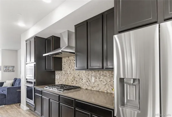 a kitchen with stainless steel appliances granite countertop a refrigerator and a stove