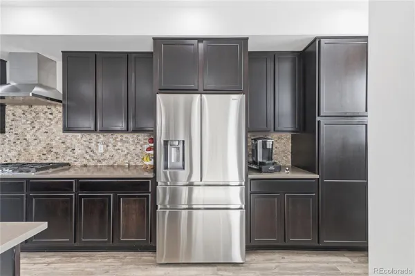 a metallic refrigerator freezer sitting in a kitchen