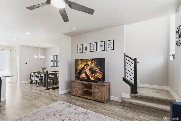 a living room with furniture a flat screen tv and kitchen view
