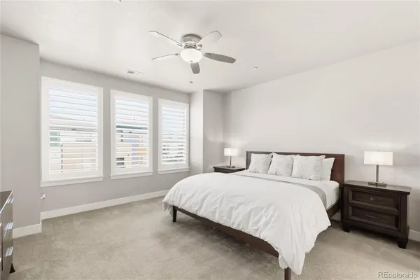 a spacious bedroom with a large bed and a chandelier