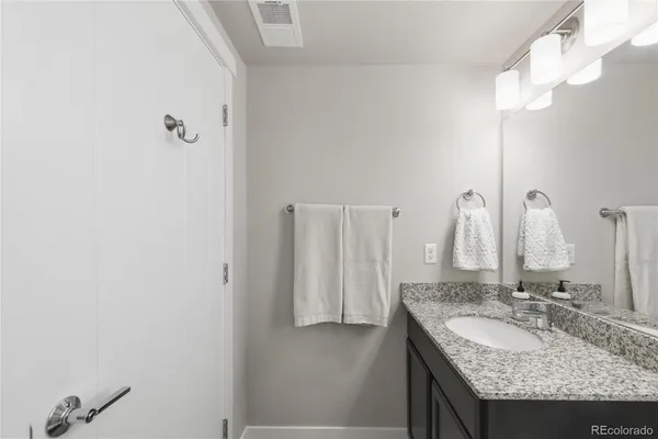 a bathroom with a granite countertop sink and a mirror