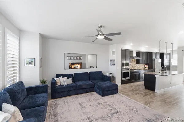 a living room with furniture kitchen view and a window