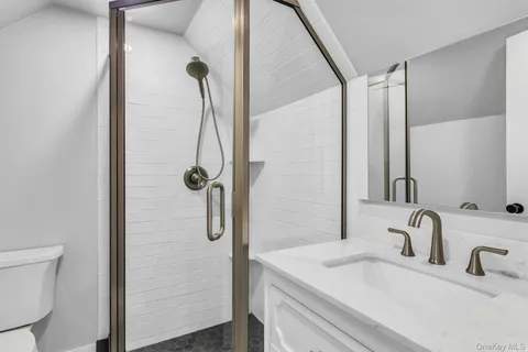 a bathroom with a sink and mirror with shower