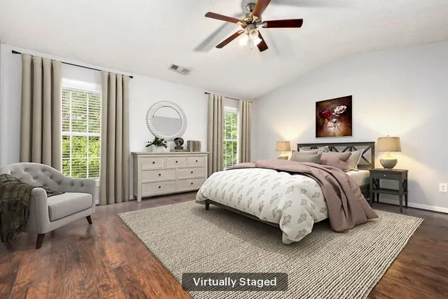 a spacious bedroom with a bed a couch and a window