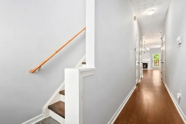 a view of a hallway with wooden floor and staircase