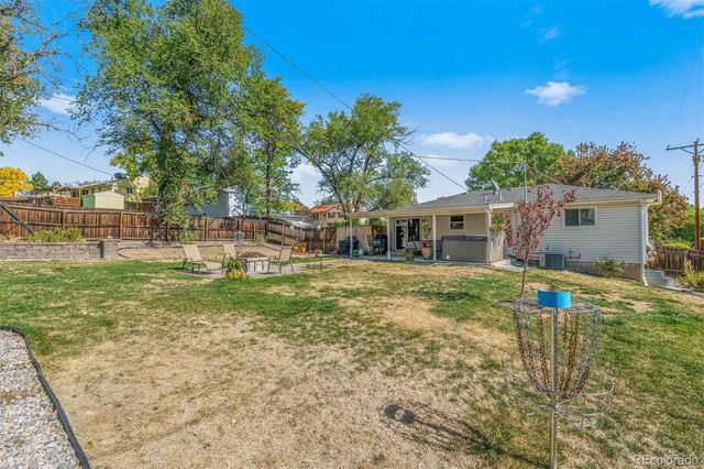 a view of a house with backyard and a tree