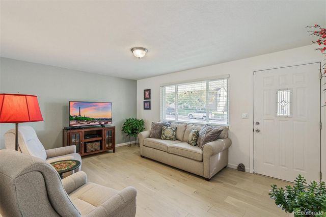a living room with furniture a flat screen tv and a large window