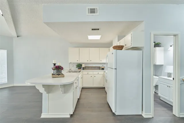 a kitchen with a sink a refrigerator and cabinets
