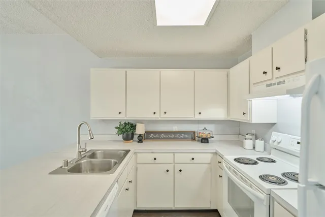 a kitchen with white cabinets sink and white appliances
