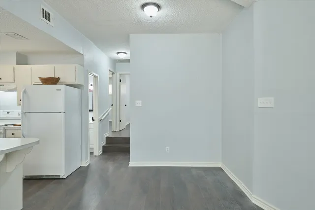 a view of a hallway with a refrigerator and a refrigerator