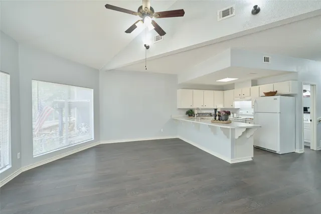 a view of a kitchen with wooden floor and electronic appliances