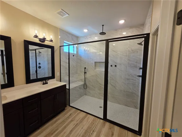 a bathroom with a shower sink and mirror