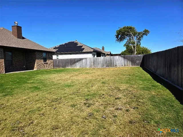 a white house with a yard and a large tree