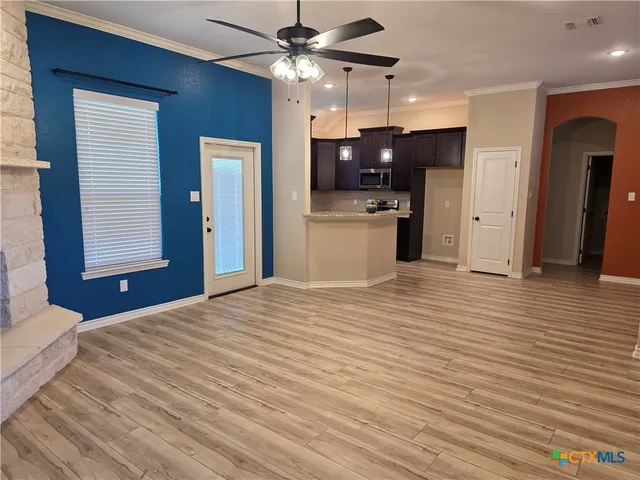 a kitchen view with wooden floor and a ceiling fan