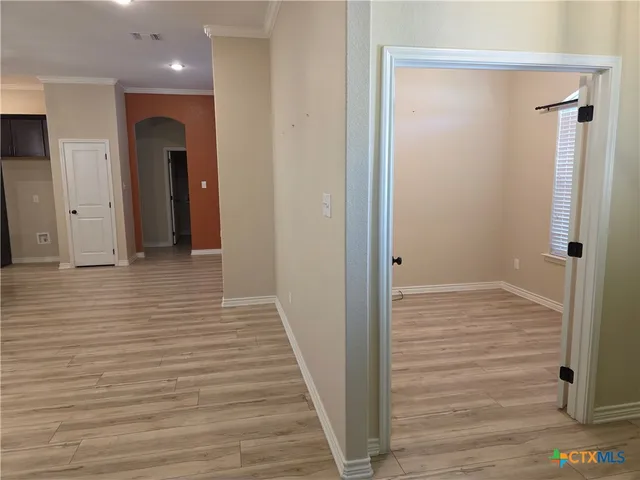 a view of a hallway with wooden floor and closet