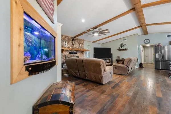 a living room with furniture a flat screen tv and a fireplace