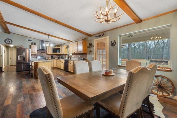 7766 North State Highway 78 Ravenna, TX 75476 - Photo 14 of 39 Dining space with a chandelier, dark wood finished floors, and a textured ceiling