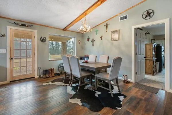 a dining room with furniture a chandelier and wooden floor