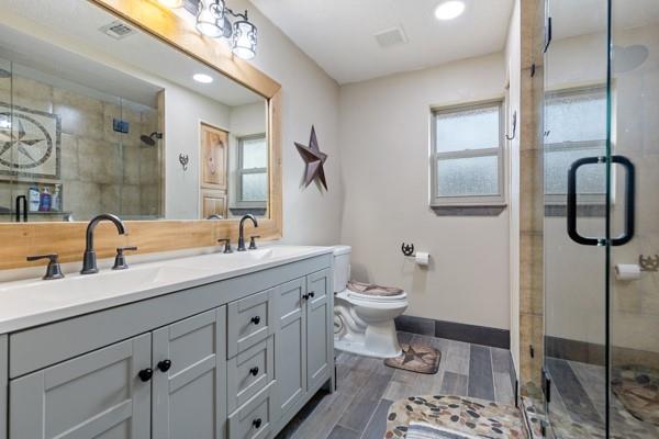 7766 North State Highway 78 Ravenna, TX 75476 - Photo 18 of 39 Full bathroom with double vanity, a shower stall, wood tiled floors, and recessed lighting
