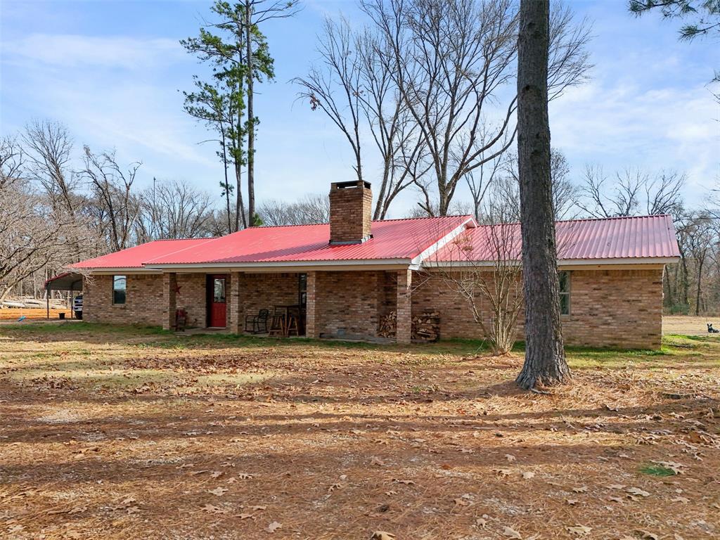 7766 North State Highway 78 Ravenna, TX 75476 - Photo 2 of 39 View of front of house featuring a chimney, brick siding, and a metal roof
