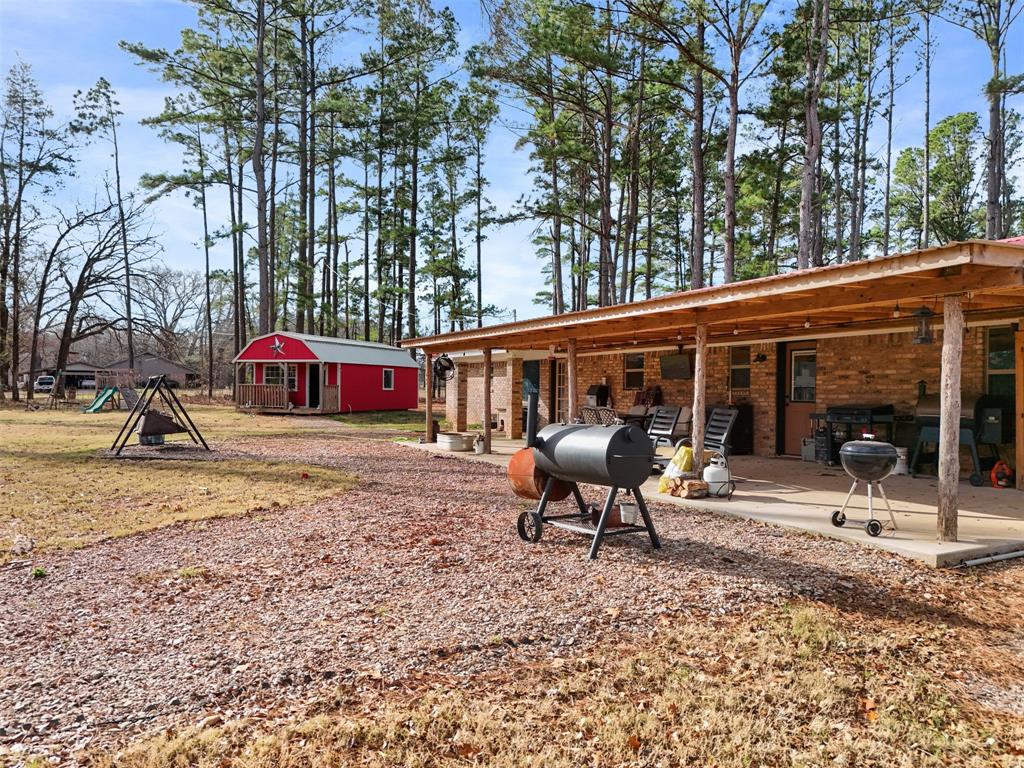 7766 North State Highway 78 Ravenna, TX 75476 - Photo 28 of 39 Rear view of house with a patio area, brick siding, and an outdoor structure