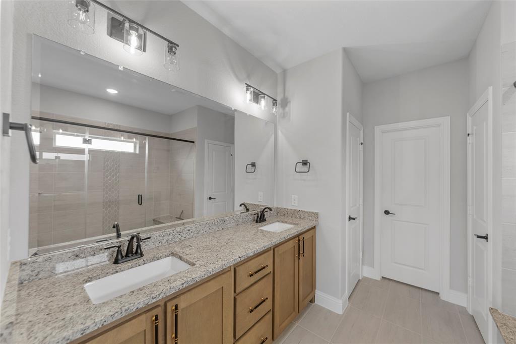 3405 Heathrow Road Mesquite, TX 75181 - Photo 13 of 30 a bathroom with a granite countertop sink a mirror and a shower