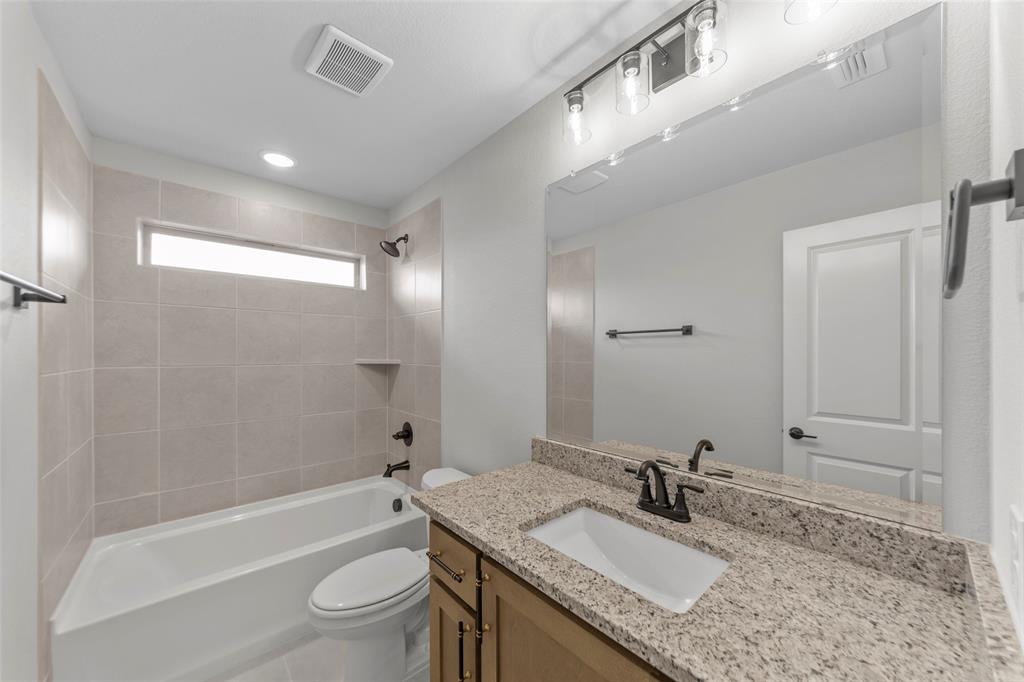 3405 Heathrow Road Mesquite, TX 75181 - Photo 21 of 30 a bathroom with a granite countertop sink a toilet a mirror and shower